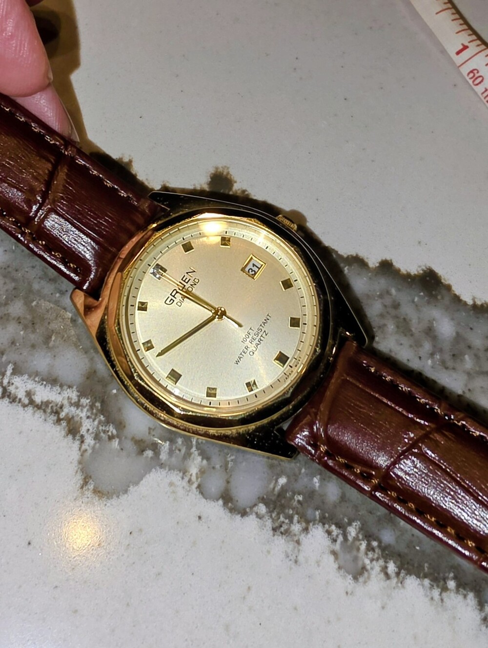 Vintage Gruen Diamond Quartz watch featuring a gold-tone case, date window at 3